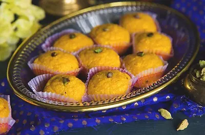 Besan laddu topped with pistachio from the 24 Carats Sweets online store, India