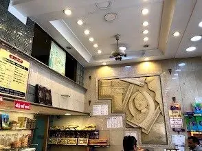 Sweets counter and menu board inside a 24 Carats Mithai Magic outlet